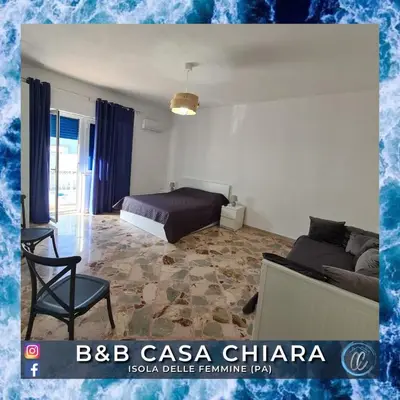 a bedroom with a bed and a chair in a room at Casa Delle Femmine in Isola delle Femmine