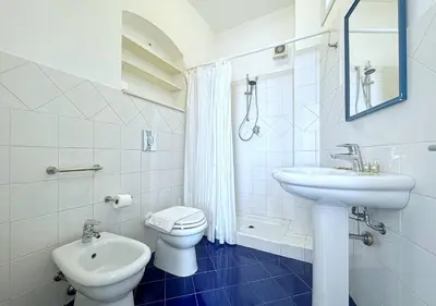a white bathroom with a toilet and a sink at Solemar Sicilia - Casa Eos in Porticello