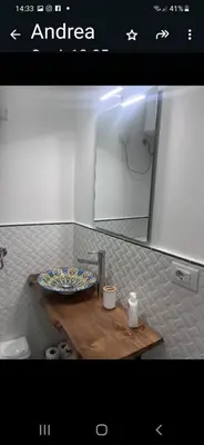 a bathroom with a sink and a mirror and a toilet at Le stanze di Rosalia in Palermo