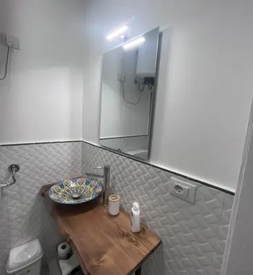 a bathroom with a wooden table and a sink at Le stanze di Rosalia in Palermo