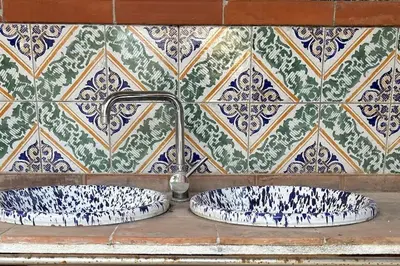 a bathroom sink with a faucet on a tiled wall at Finc house in Palermo