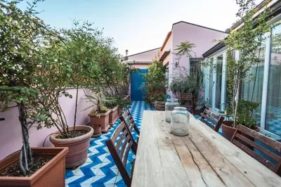 an outdoor patio with a wooden table and potted plants at iFlat Sicilia Le terrazze blu in Palermo