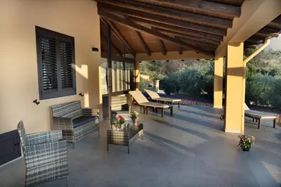 a patio with benches and tables on a house at Villa Serena - vasca idromassaggio in Borgetto