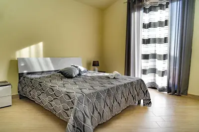 a bedroom with a bed with a cat laying on it at Villa Serena - vasca idromassaggio in Borgetto