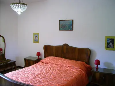 a bedroom with a bed with a red blanket at Casa Gelferraro in Calatafimi
