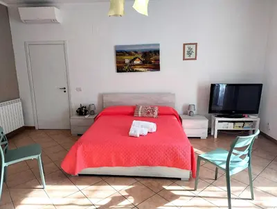 a bedroom with a red bed and a flat screen tv at Rimpetto alle Clarisse in Palermo