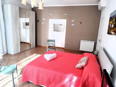 a bedroom with a red bed and a mirror at Rimpetto alle Clarisse in Palermo