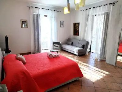 a bedroom with a red bed and a couch at Rimpetto alle Clarisse in Palermo