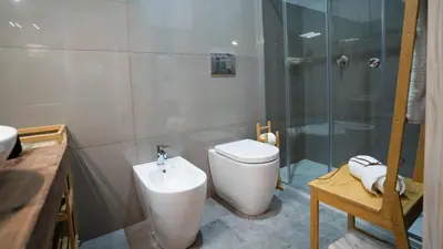 a bathroom with a toilet and a shower and a sink at Le Stanze del Duomo in Partinico