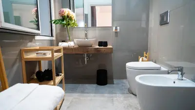 a bathroom with a white toilet and a sink at Le Stanze del Duomo in Partinico