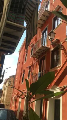 a red building with a tree in front of it at Casa Rosa in Palermo