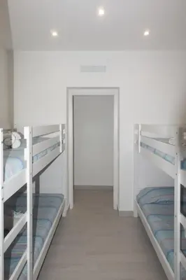 a room with two bunk beds and a door at Lido Azzurro Sea Apartments in Carini