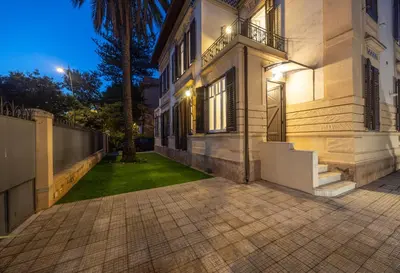 a large white building with a walkway in front at Aria di sale in Palermo