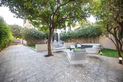 a patio with couches and tables and trees at Aria di sale in Palermo