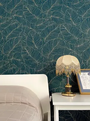 a bedroom with a wall with a green leaf wallpaper at Loriano Apartment in Capaci