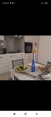 a kitchen with a table with a blue vase on it at appartamento gioioso in Castellammare del Golfo