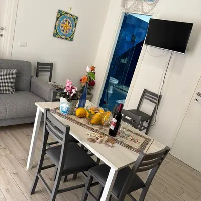 a kitchen with a table with chairs and a sink at appartamento gioioso in Castellammare del Golfo
