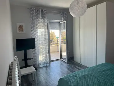 a bedroom with a bed and a sliding glass door at Casa vacanze Rosalinda House di fronte al mare di Palermo in Palermo
