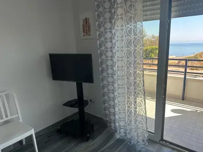 a room with a flat screen tv and a window at Casa vacanze Rosalinda House di fronte al mare di Palermo in Palermo