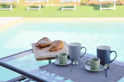a table with cups and croissants on a table with cups and coffeeisers at Dimora Masi di GN Real Escapes in Castellammare del Golfo