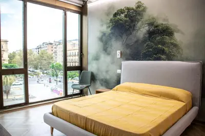 a bedroom with a bed with a painting on the wall at Politeama Crystal Rooms in Palermo