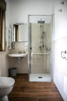 a bathroom with a shower and a toilet and a sink at Politeama Crystal Rooms in Palermo