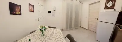 a dining room with a table with a vase of flowers on it at Murriali Apartment in Monreale