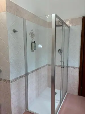 a shower with a glass door in a bathroom at Dojo idro rooms in Carini