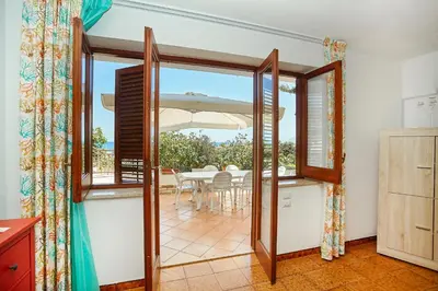 a kitchen with a door open to a dining room with a table at Villa Azzurra a pochi passi dal mare in Castellammare del Golfo