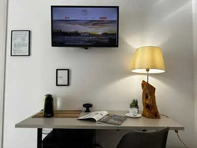 a desk with a lamp and a computer on a wall at Terra d'amuri Rooms in Terrasini