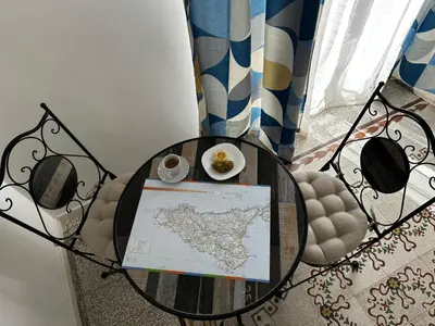 a table with a map and a plate of food on it at Terra d'amuri Rooms in Terrasini