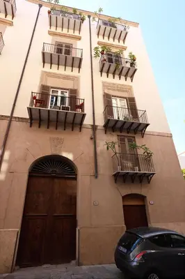 a building with balconies and a car parked in front of it at Oasi Porta Felice in Palermo