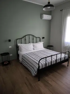 a bedroom with a bed with a black frame and white pillows at Selenite Home in Palermo