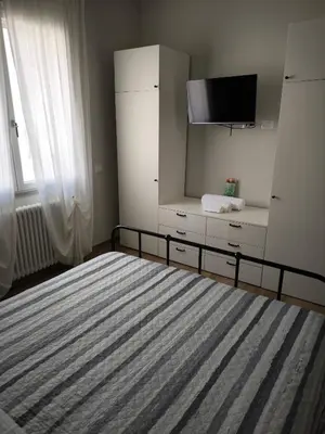 a bedroom with a bed and a dresser with a tv at Selenite Home in Palermo