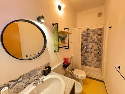 a bathroom with a sink and a toilet and a mirror at Backpackers House - Ballaró in Palermo