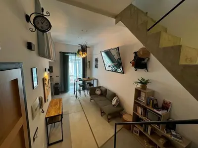 a living room with a staircase with a couch and a table at Backpackers House - Ballaró in Palermo