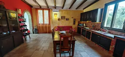 a kitchen with red walls and a table and chairs at Villa Samay Luxury House in Carini