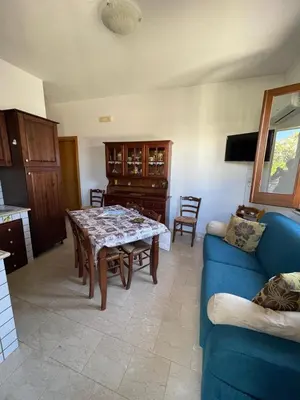 a living room with a table and a blue couch at Appartamento Gelsomino in San Vito lo Capo
