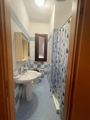a bathroom with a white sink and blue tiles at Appartamento Giglio in San Vito lo Capo
