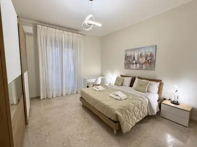 a bedroom with a bed and a large window at Dantes House in Palermo