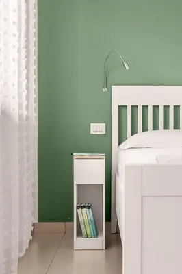a bedroom with a white bed and a white lamp at More Holidays Beach in Mondello