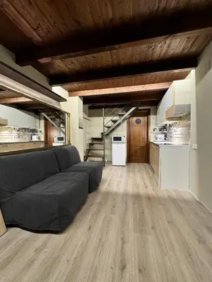 a living room with a couch and a kitchen at Loft Cattedrale Palermo in Palermo