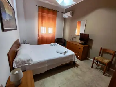 a bedroom with a bed and a tv and a chair at Politeama guest house Palermo Agave in Palermo