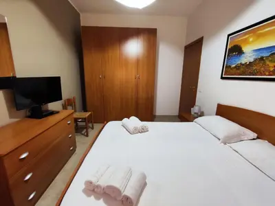 a bedroom with a white bed and a tv at Politeama guest house Palermo Agave in Palermo