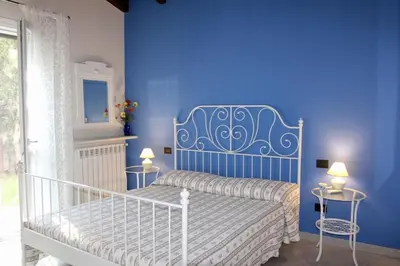 a bedroom with a bed with a blue wall at Villa Enza Bellissima villa con piscina in Terrasini