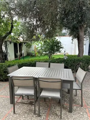 a wooden table and chairs with a table and trees at Villa Marea Mondello in Palermo