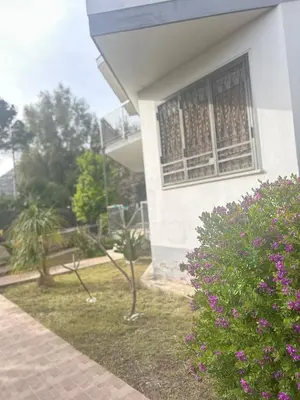 a building with a window and a bush with purple flowers at Villa Mia Mondello, 200m to beach, private parking in Palermo