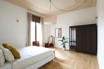 a bedroom with a white bed and a potted plant at Casa Disìu in Palermo
