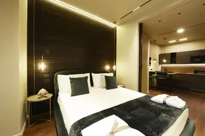 a bedroom with a large bed with a black headboard at Di fronte a Suite in Palermo
