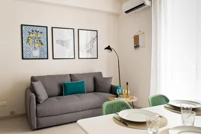 a living room with a couch and a table at Verdeacqua Home in Castellammare del Golfo